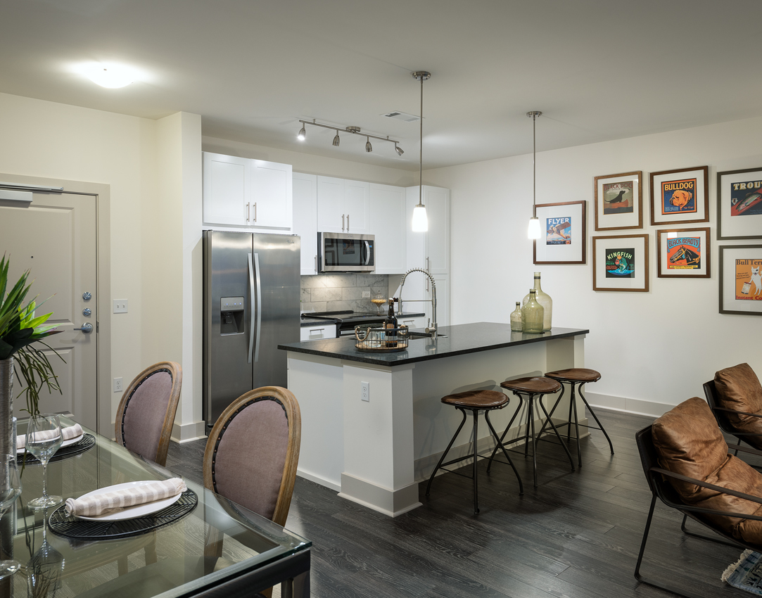 Cirro luxury apartments' kitchen & dining area in King of Prussia, PA, with table, chairs, countertop, sink, ref, cabinets, & cooking appliances